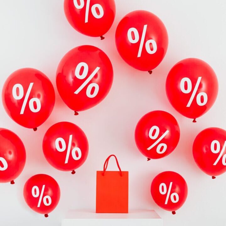 A red bag and some balloons with percent signs on them